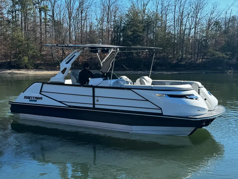 Slide: The Image of 2025 Montara Surf Boss 2.0 25 boat on a calm lake. - 2