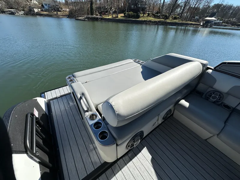 Slide: The Image of 2025 Montara Surf Boss 2.0 25 boat interior with seating and cup holders on a lake. - 9