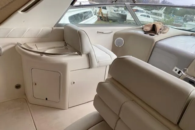 Slide: The Image of Interior of a 1998 Sea Ray 330 Sundancer boat with beige seating and dashboard. - 3