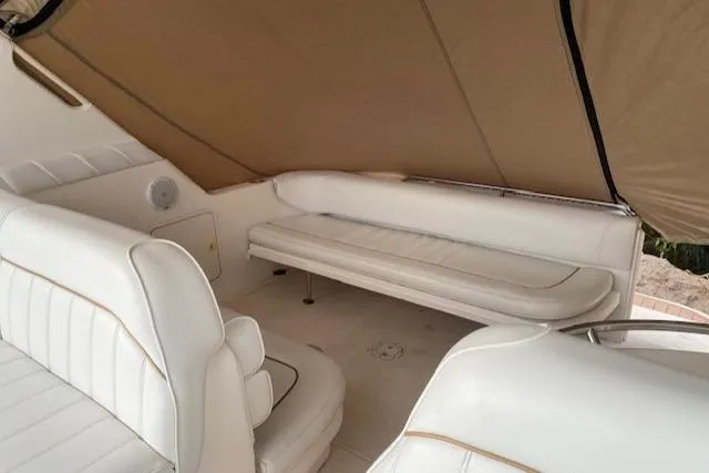 Slide: The Image of 1998 Sea Ray 330 Sundancer interior with white seating and tan canopy. - 4