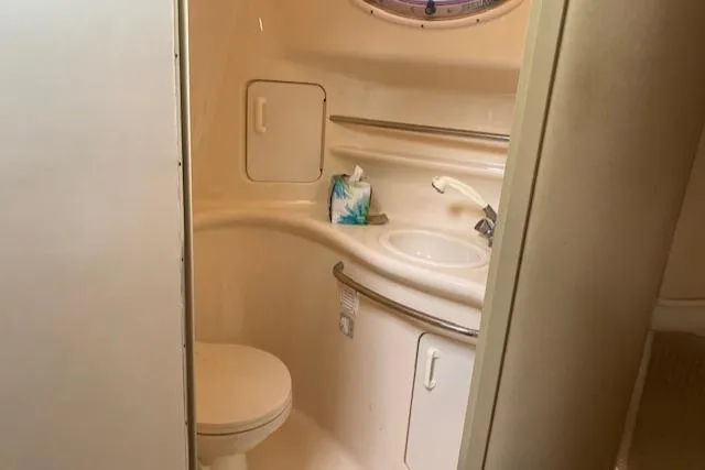 Slide: The Image of 1998 Sea Ray 330 Sundancer bathroom with sink, toilet, and storage cabinet. - 6