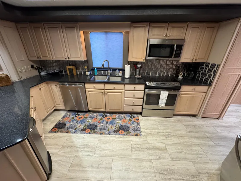 Slide: The Image of Modern kitchen in a 1997 Sumerset 85x18 houseboat with stainless steel appliances and light wood cabinets. - 11