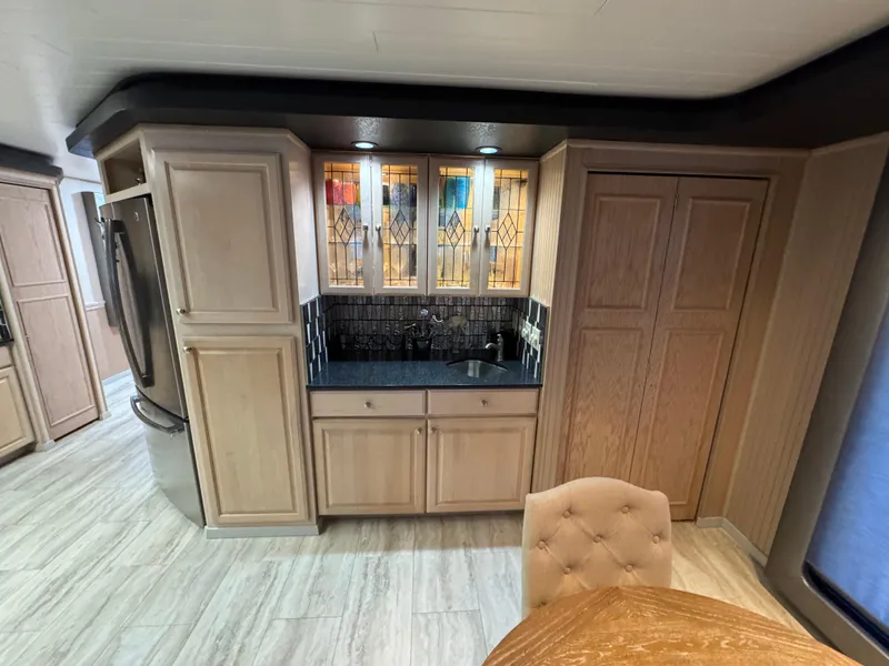 Slide: The Image of 1997 Sumerset 85x18 interior with wood cabinets, stained glass, and modern appliances. - 12