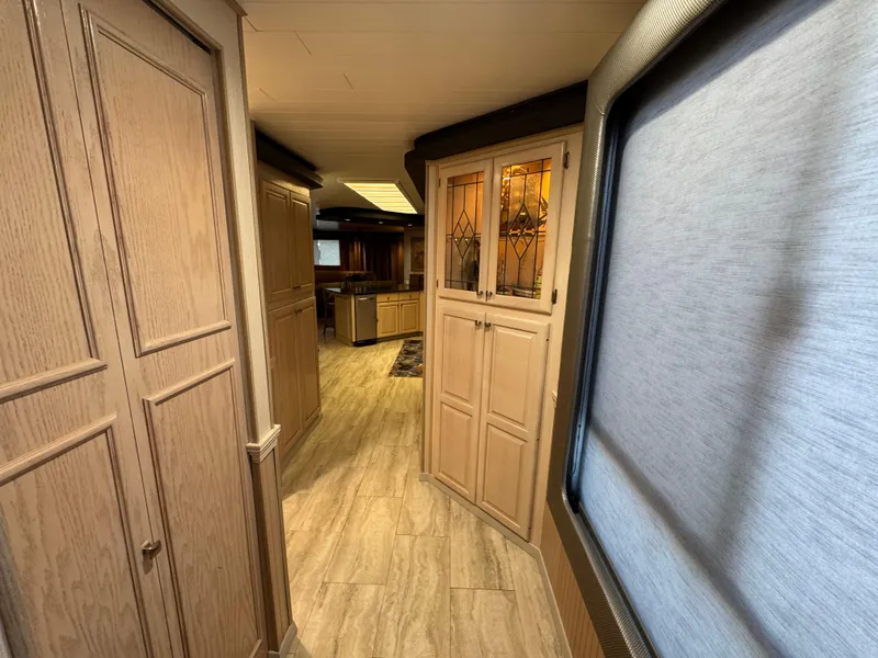 Slide: The Image of Interior hallway of a 1997 Sumerset 85x18 houseboat with wooden cabinets and flooring. - 15