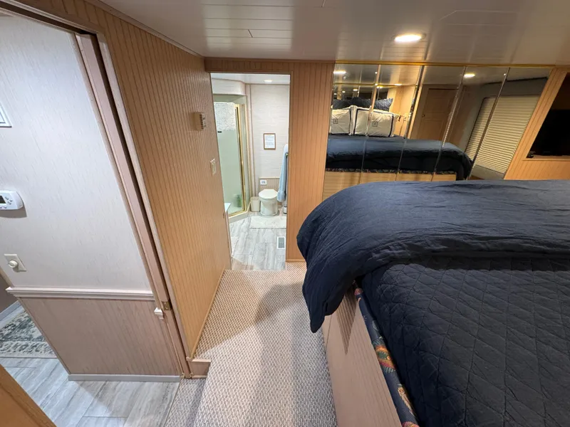 Slide: The Image of Interior of 1997 Sumerset 85x18 houseboat bedroom with mirrored wall and adjacent bathroom. - 19
