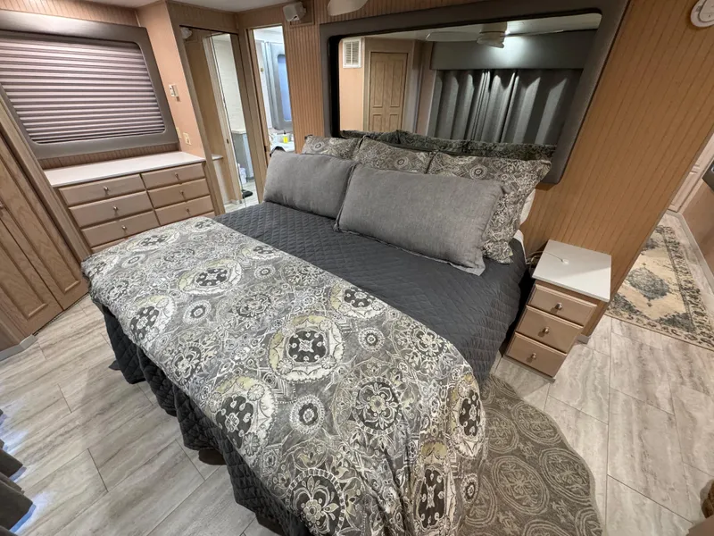 Slide: The Image of Luxurious bedroom interior in a 1997 Sumerset 85x18 houseboat, featuring elegant bedding and ample storage. - 27