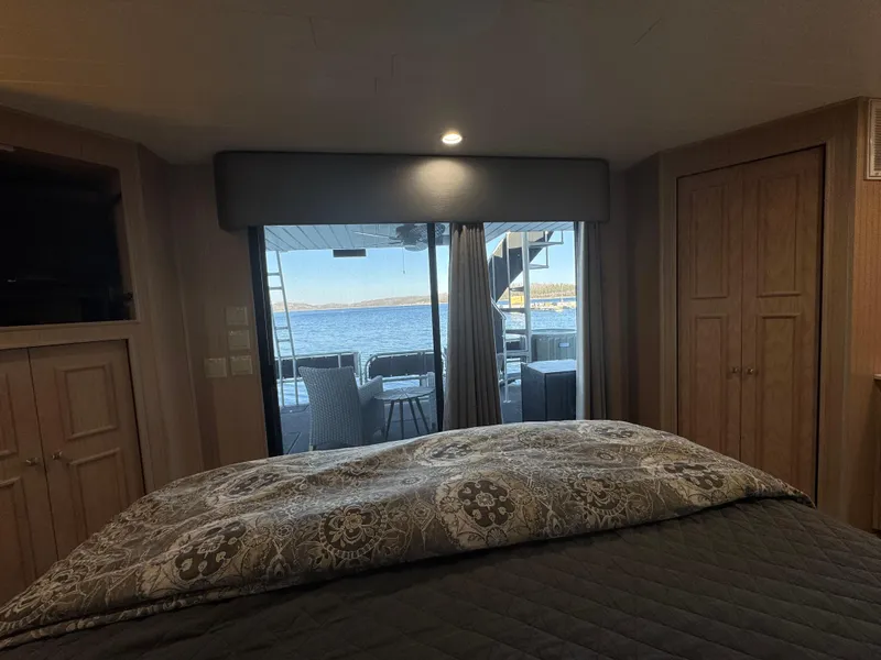 Slide: The Image of Interior view of 1997 Sumerset 85x18 houseboat bedroom with lake view through sliding doors. - 30