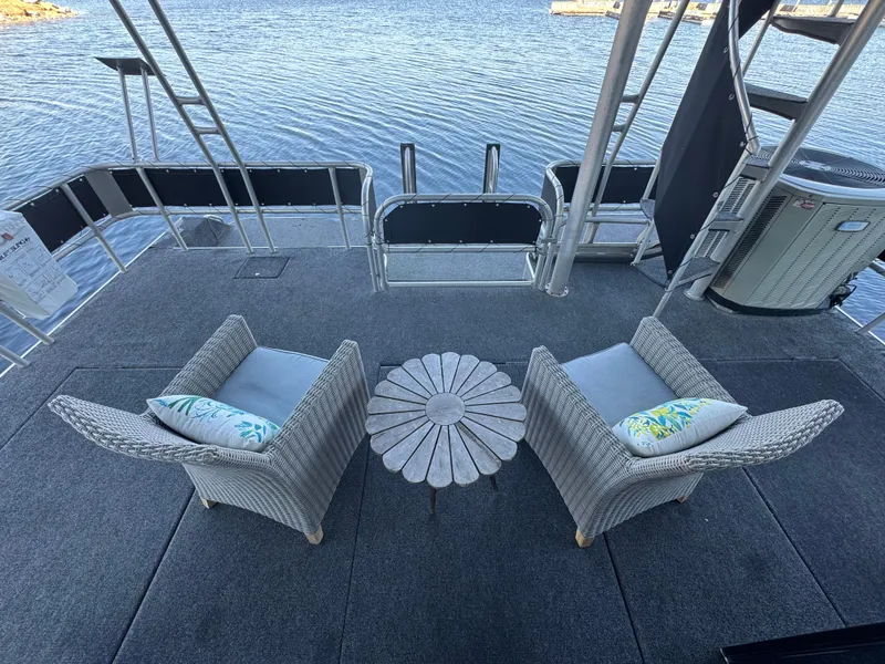 Slide: The Image of Two wicker chairs on a Sumerset 85x18 houseboat deck, overlooking water. - 34