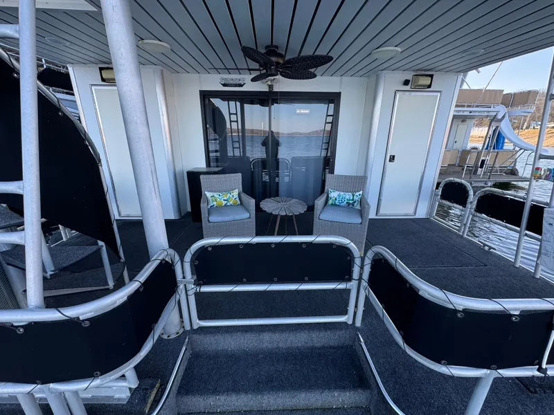 Slide: The Image of 1997 Sumerset 85x18 houseboat deck with seating, spiral staircase, and waterfront view. - 35