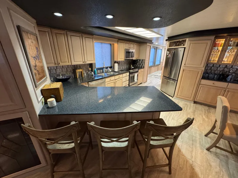 Slide: The Image of Luxurious kitchen interior of a 1997 Sumerset 85x18 houseboat with modern appliances and seating. - 9