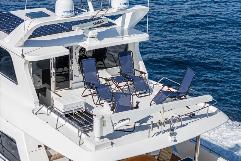 Slide: The Image of Johnson Pilothouse 70 Motor Yacht 2002 with deck chairs on the deck. - 29