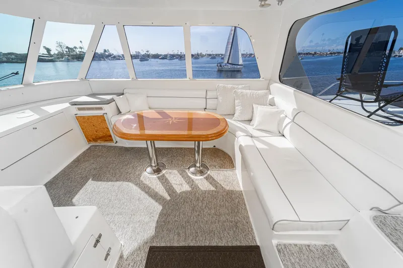 Slide: The Image of Interior of 2002 Johnson Pilothouse 70 Yacht with white sofa and wooden table. - 34