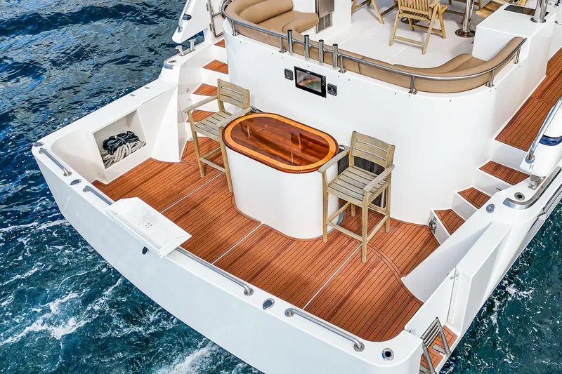 Slide: The Image of Johnson Pilothouse 70 Motor Yacht 2002, luxurious deck with wood flooring and seating area. - 38