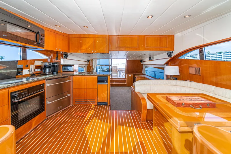 Slide: The Image of Interior of 2002 Johnson Pilothouse 70 Yacht, featuring modern kitchen and seating area. - 44