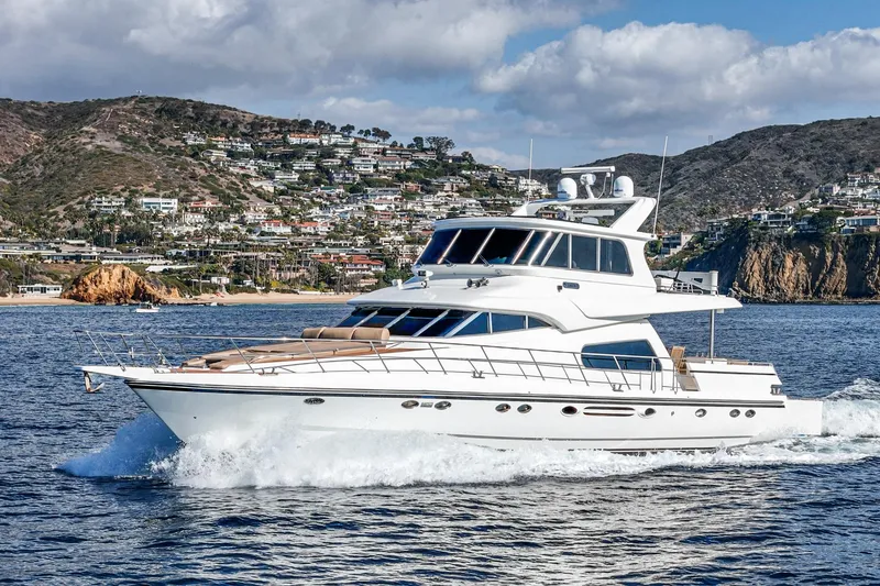 Slide: The Image of Johnson Pilothouse 70 Motor Yacht 2002 cruising on the sea near coastal landscape. - 5