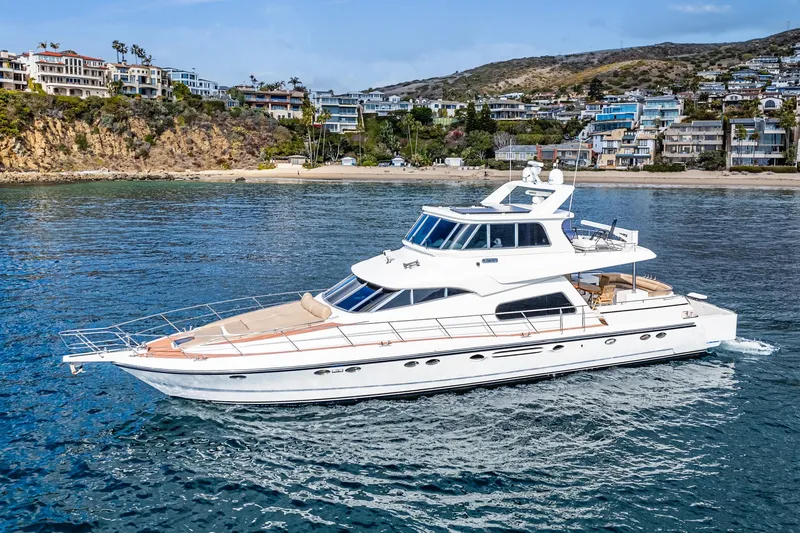 Slide: The Image of Johnson Pilothouse 70 Motor Yacht 2002 near coastal scenery. - 8