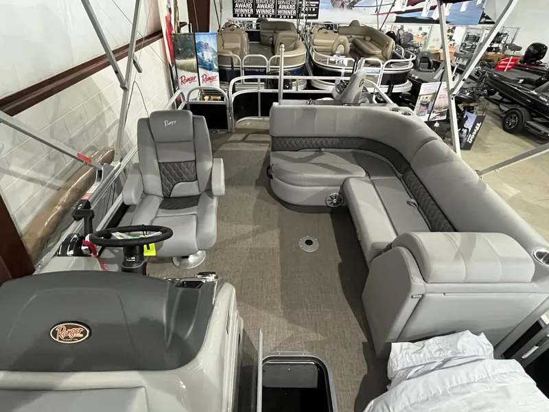 Slide: The Image of 2025 Ranger 223FC pontoon boat interior with gray seating and steering console. - 4