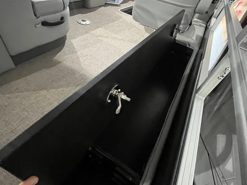 Slide: The Image of 2025 Ranger 223FC interior storage compartment with open lid and handle. - 7