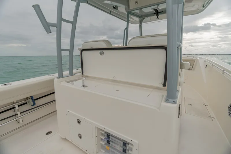 Slide: The Image of 2021 Cobia 320 Center Console boat, spacious deck, ocean backdrop, overcast sky. - 14