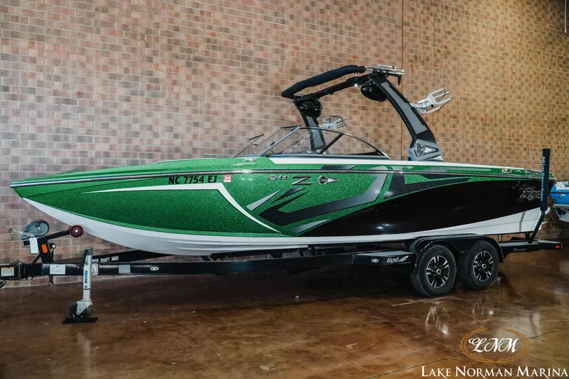 Slide: The Image of 2018 Tigé Z3 boat in green and black on a trailer at Lake Norman Marina. - 1