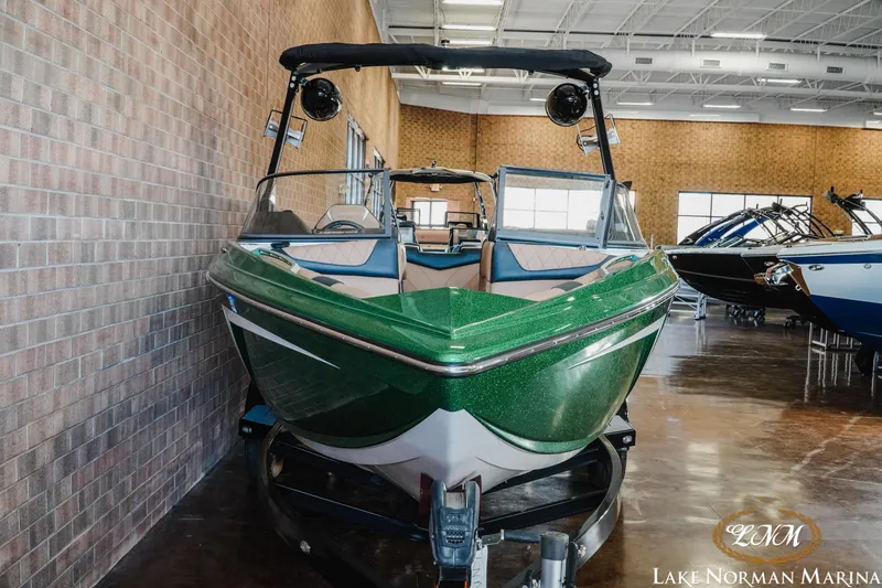 Slide: The Image of 2018 Tigé Z3 boat in showroom, green exterior, displayed at Lake Norman Marina. - 3