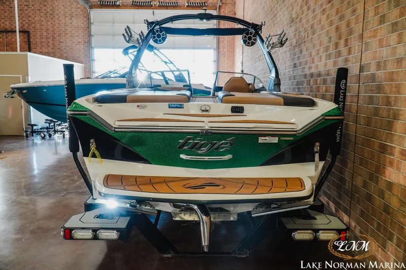 Slide: The Image of 2018 Tigé Z3 boat in marina showroom, rear view with vibrant green accents. - 5