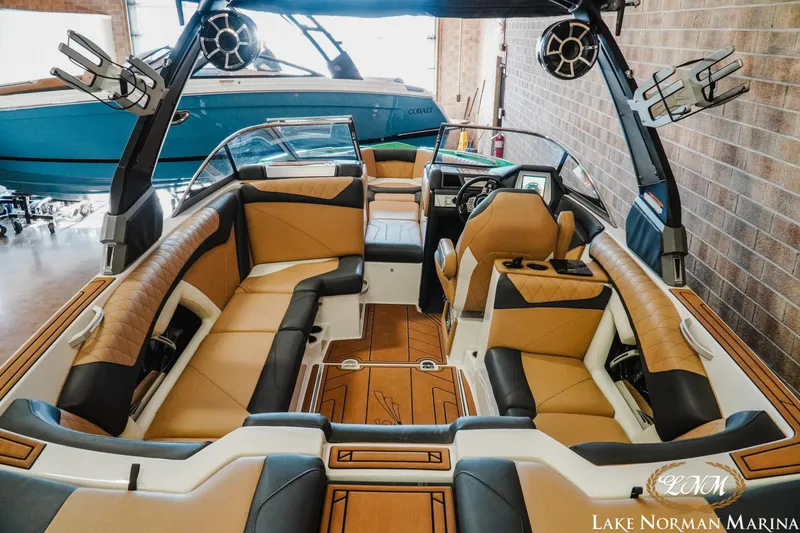 Slide: The Image of 2018 Tigé Z3 boat interior with tan and black seating, advanced dashboard, and tower speakers. - 6