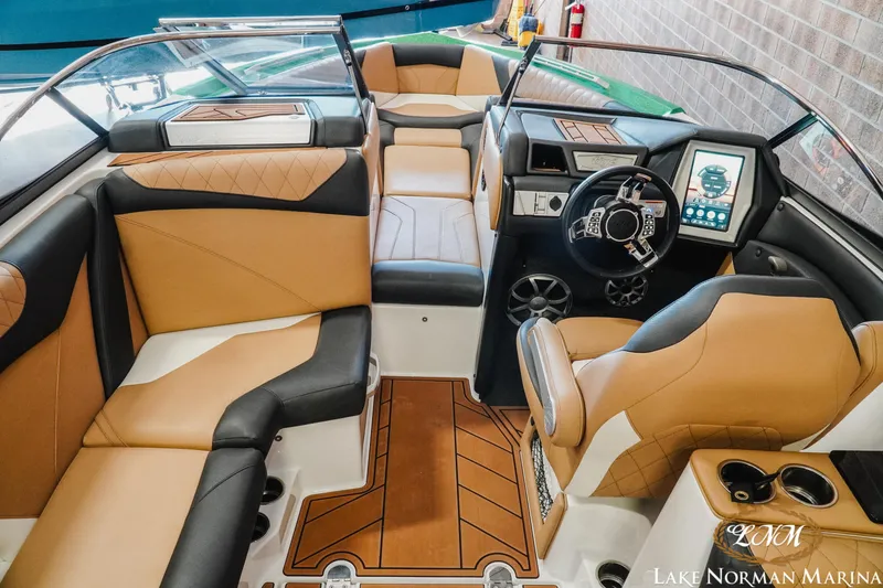Slide: The Image of 2018 Tigé Z3 boat interior with tan and black seating, modern dashboard, and steering wheel. - 8