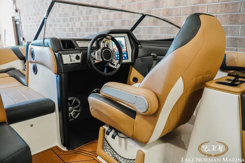 Slide: The Image of 2018 Tigé Z3 boat interior with tan and black seating, modern dashboard, and steering wheel. - 9