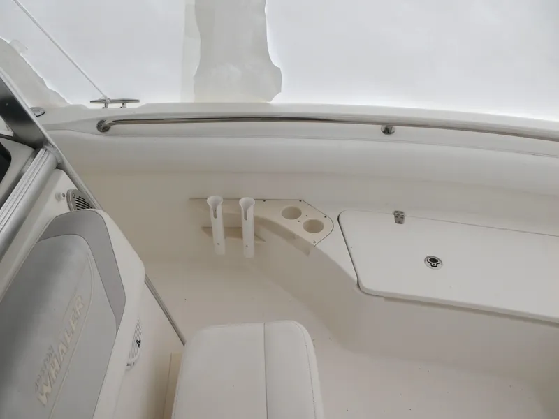Slide: The Image of 2014 Boston Whaler 220 Outrage interior, featuring seating and storage compartments. - 11