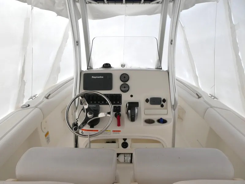 Slide: The Image of 2014 Boston Whaler 220 Outrage boat console with steering wheel and navigation equipment. - 15