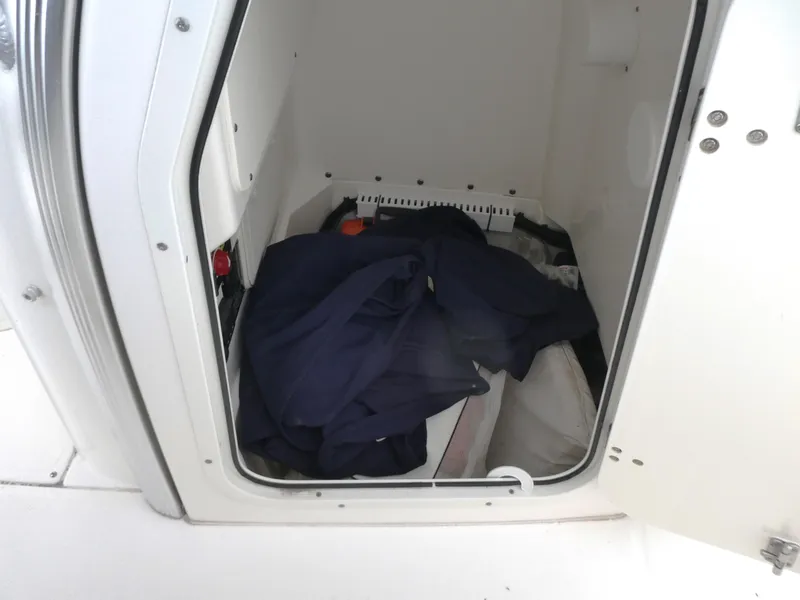 Slide: The Image of Storage compartment in a 2014 Boston Whaler 220 Outrage boat, containing various items. - 16