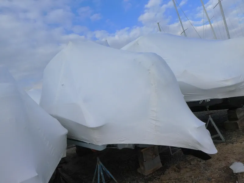 Slide: The Image of 2014 Boston Whaler 220 Outrage boat covered in protective wrap, stored outdoors. - 2