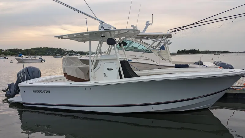 Slide: The Image of 2017 Regulator 23 boat docked on calm water at sunset. - 10