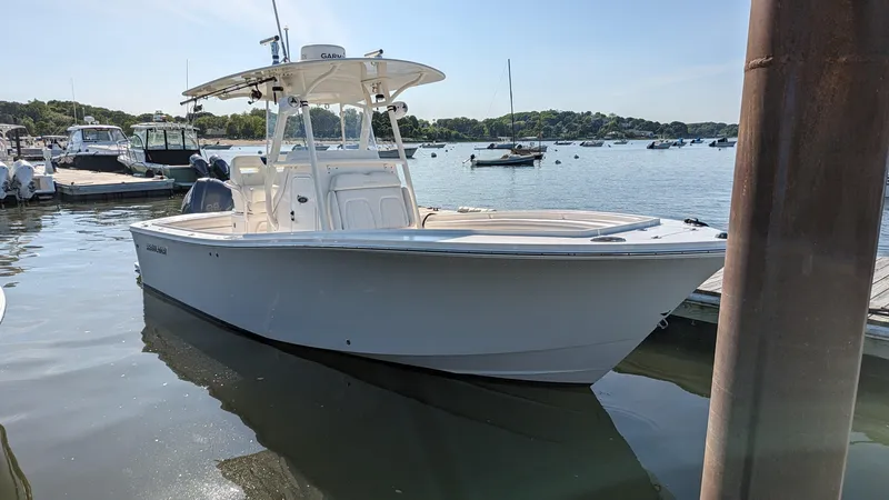 Slide: The Image of 2017 Regulator 23 boat docked in a marina, surrounded by calm water and other boats. - 17
