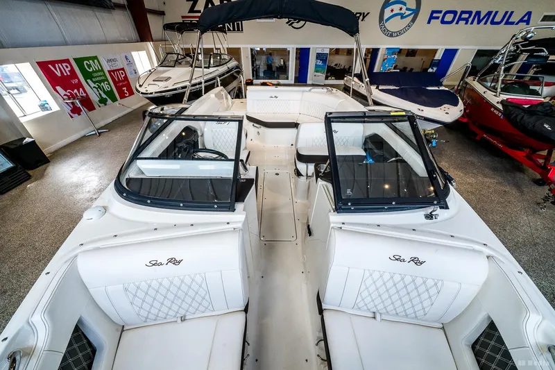 Slide: The Image of 2020 Sea Ray 230SLX boat interior in showroom, featuring white seating and sleek design. - 20