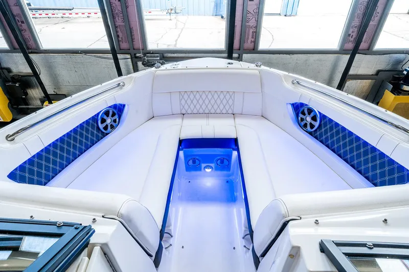 Slide: The Image of Interior of 2020 Sea Ray 230SLX boat with blue LED lighting and cushioned seating. - 24
