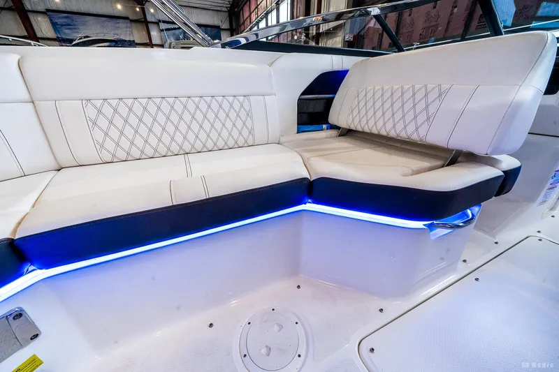 Slide: The Image of 2020 Sea Ray 230SLX boat interior with white leather seating and blue LED lighting. - 25