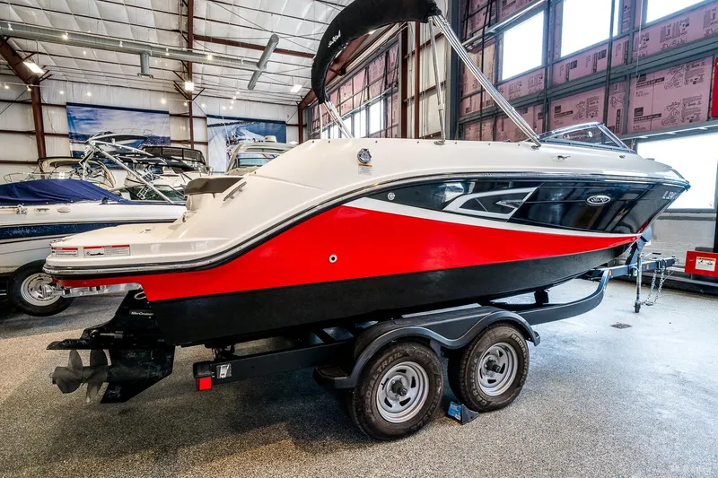 Slide: The Image of 2020 Sea Ray 230SLX boat in showroom, red and black design, on trailer. - 4