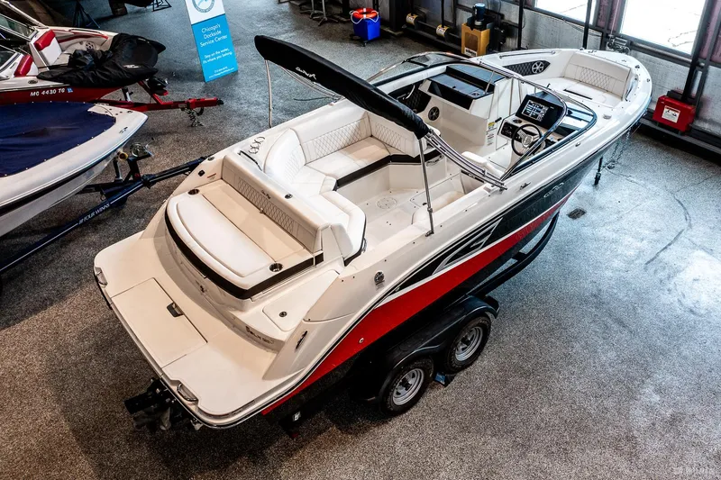 Slide: The Image of 2020 Sea Ray 230SLX boat on trailer in showroom, featuring sleek design and spacious seating. - 6