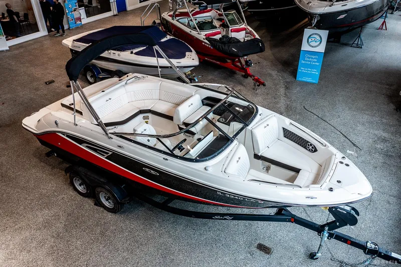 Slide: The Image of 2020 Sea Ray 230SLX boat on display in showroom, featuring sleek design and trailer. - 7