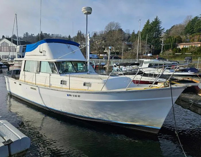 The Image of 1978 Mainship 34 Sedan boat docked in a marina, surrounded by other vessels. - 0