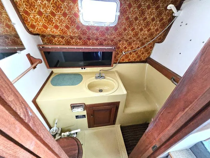 Slide: The Image of 1978 Mainship 34 Sedan bathroom with vintage decor, sink, and shower area. - 13