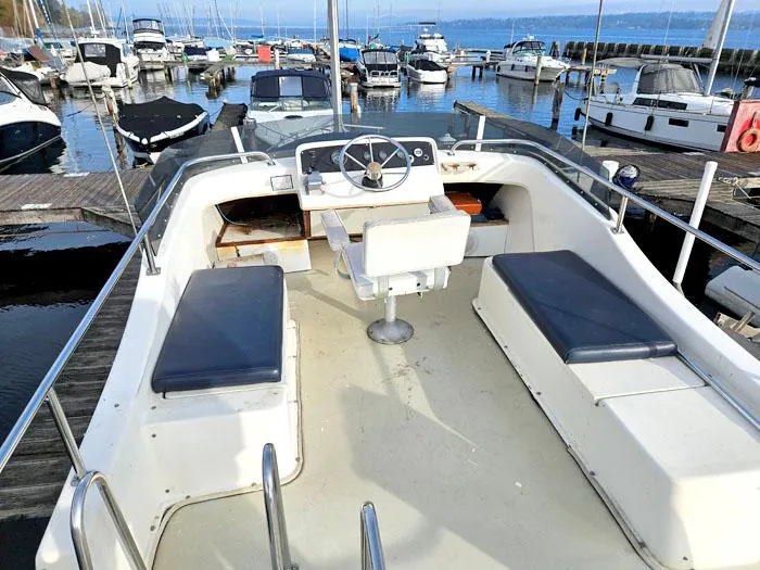 Slide: The Image of 1978 Mainship 34 Sedan boat interior with seating and steering, docked at a marina. - 17