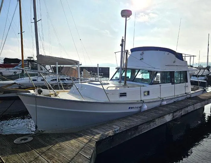 Slide: The Image of 1978 Mainship 34 Sedan docked at marina under clear sky. - 3
