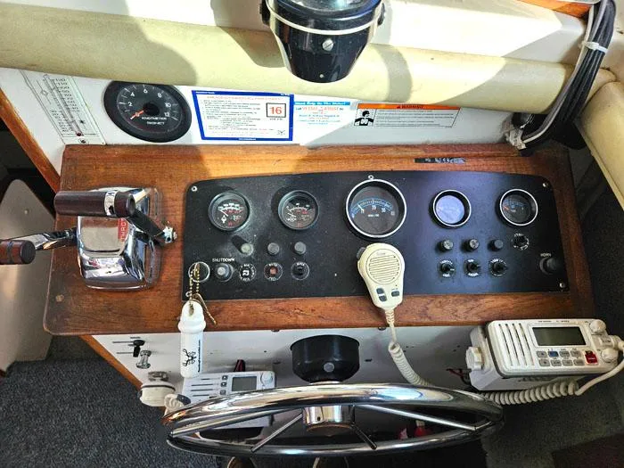 Slide: The Image of Dashboard of a 1978 Mainship 34 Sedan with gauges, controls, and a steering wheel. - 7
