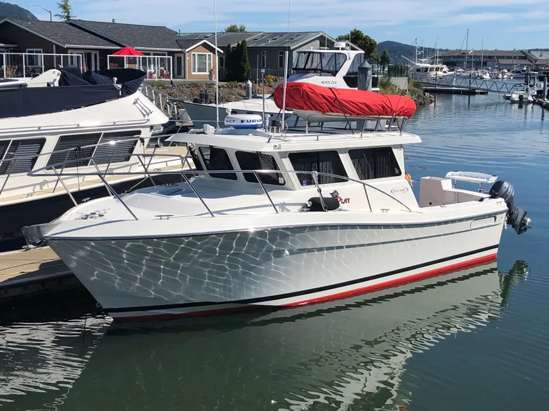 The Image of 2005 Ocean Sport Roamer 30 boat docked in a marina, reflecting on calm water. - 0