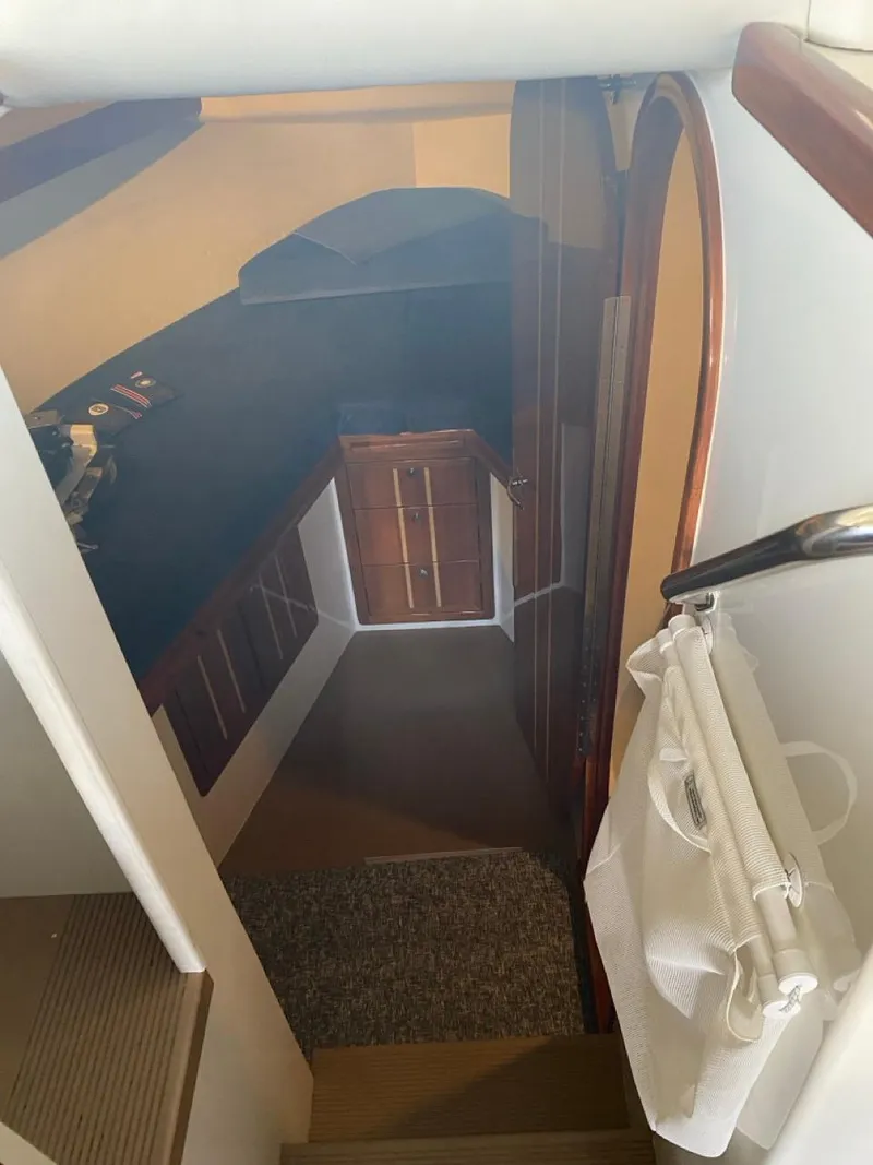 Slide: The Image of Interior view of 2005 Ocean Sport Roamer 30 boat, featuring wooden cabinetry and stairs. - 16