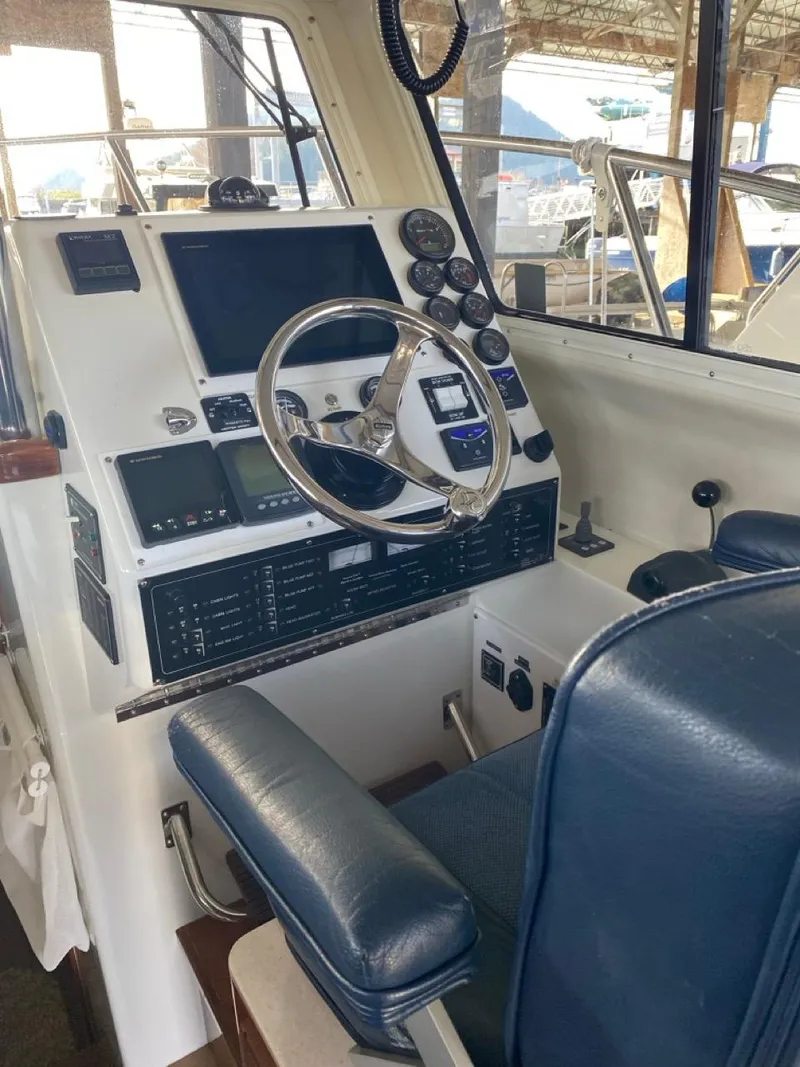 Slide: The Image of Interior helm of 2005 Ocean Sport Roamer 30 with navigation controls and leather seating. - 17