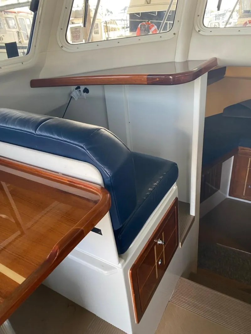 Slide: The Image of Interior of 2005 Ocean Sport Roamer 30 with blue seating and wooden accents. - 18